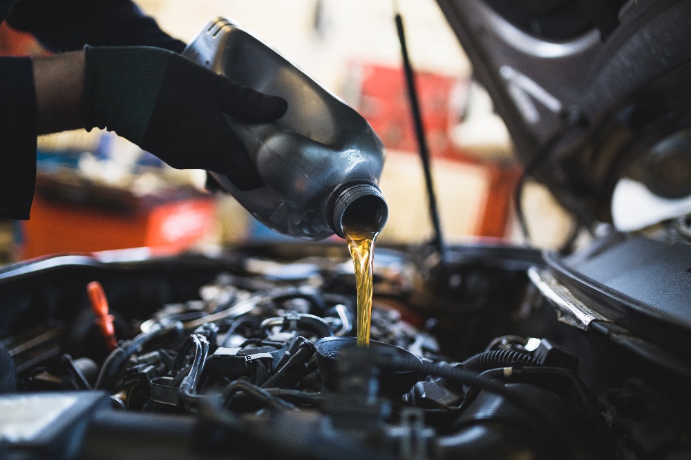 A driver checking tire pressure while performing off-road vehicle maintenance on trail.