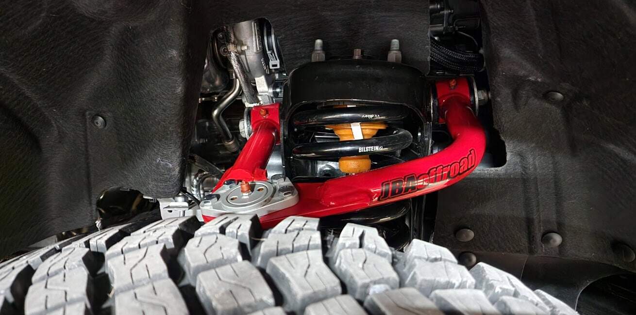 Full view of a red JBA Offroad upper control arm.